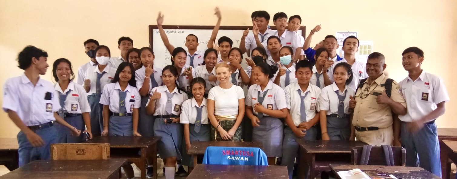 Christina Soltau inmitten ihrer Schüler in einer Schule auf Bali. Alle in Schuluniform und fröhlich