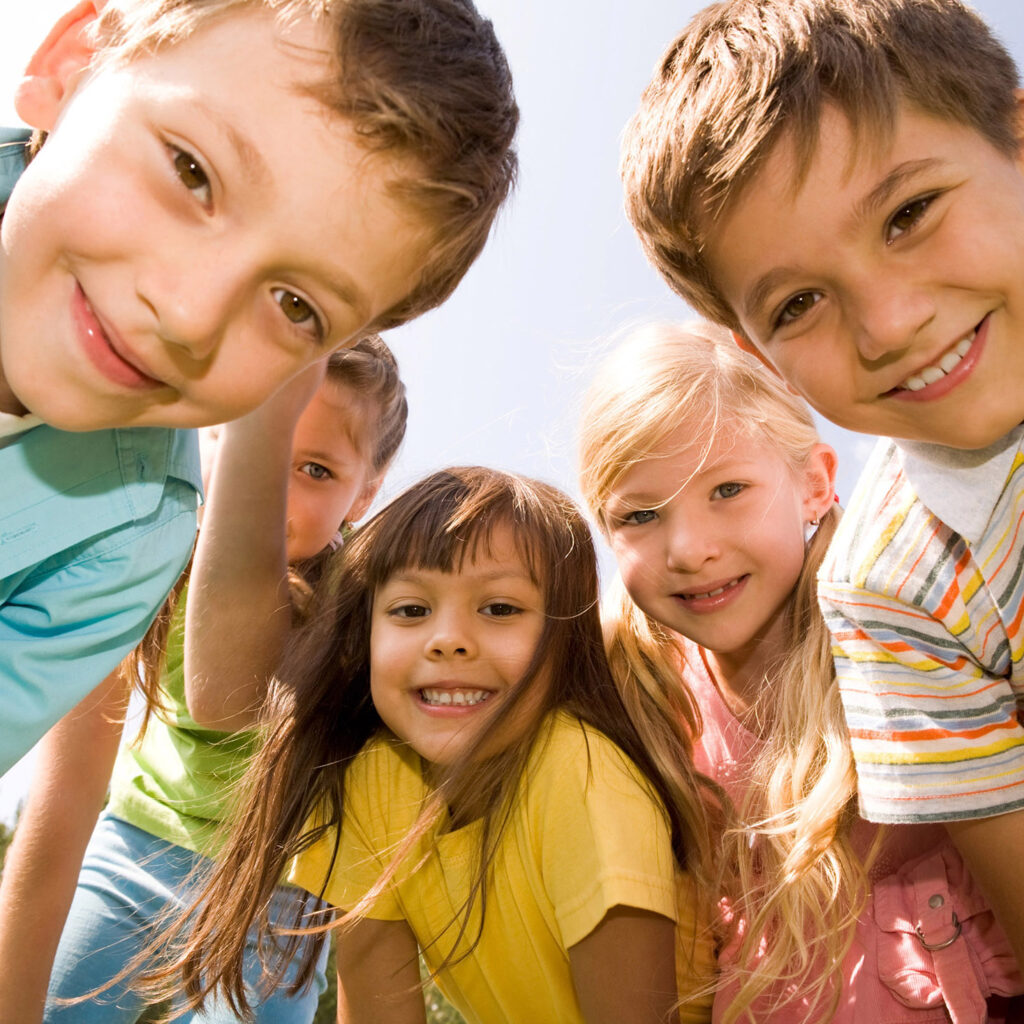 Fünf lächelnde Kinder blicken die die Kamera